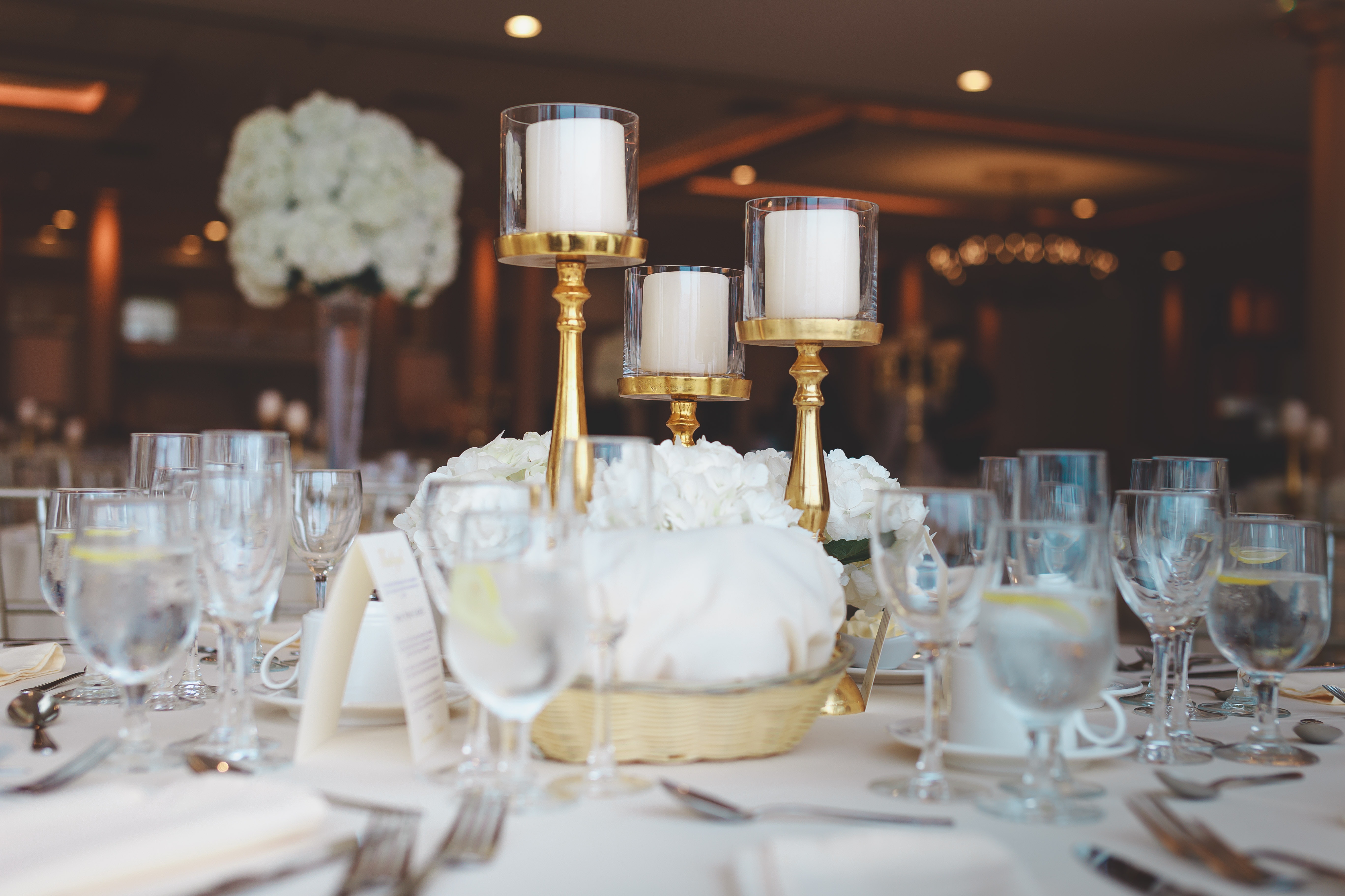 close up of a table at a wedding. All white with a white rose