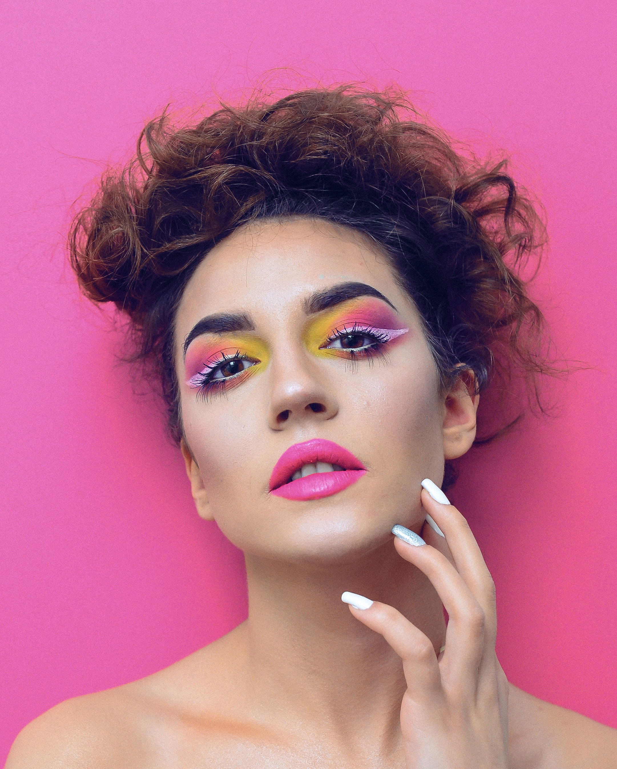 studio portrait of a woman with a pink background